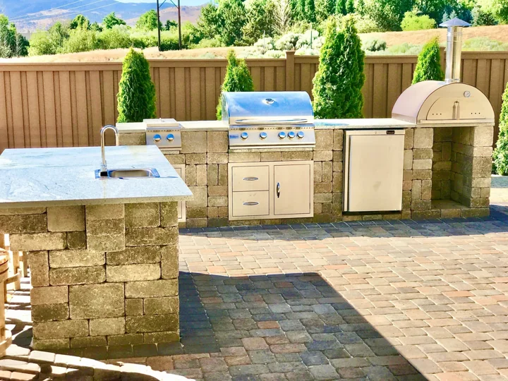 Outdoor kitchen beside a paver patio