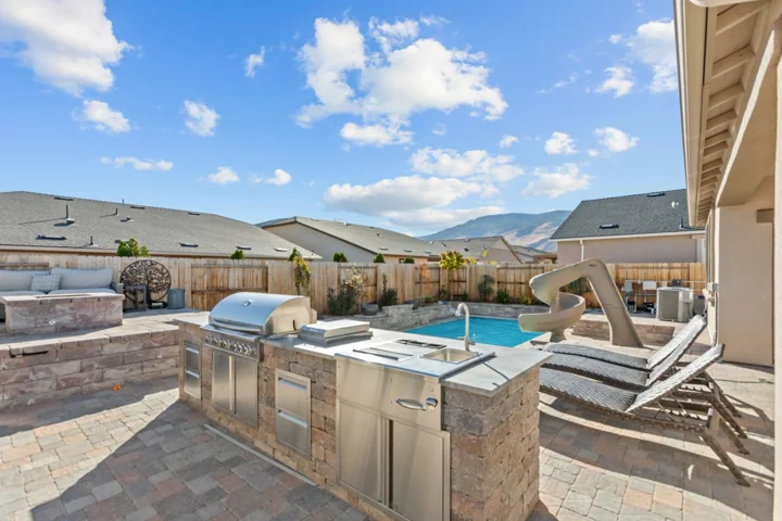 Poolside outdoor kitchen and hardscape with mountain views